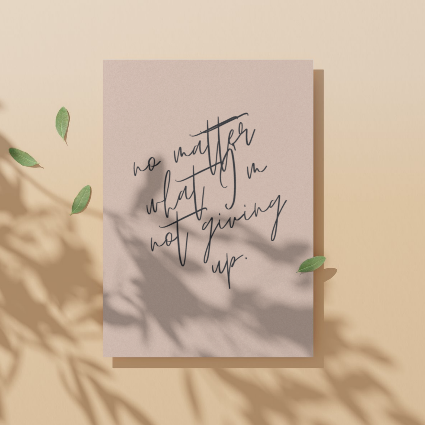 Picture of printable "No Matter What I'm Not Giving Up" artwork hanging on a beige wall in front of a plant.