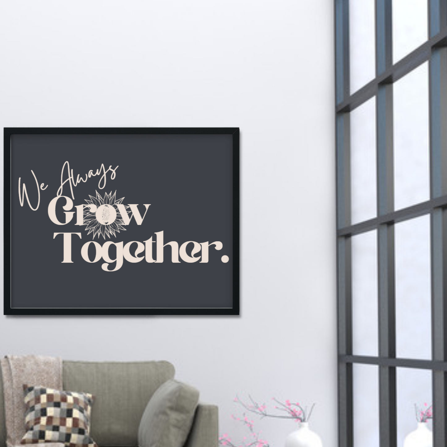 Picture of a piece of black framed artwork that has the words "We Always Grow Together" on it.