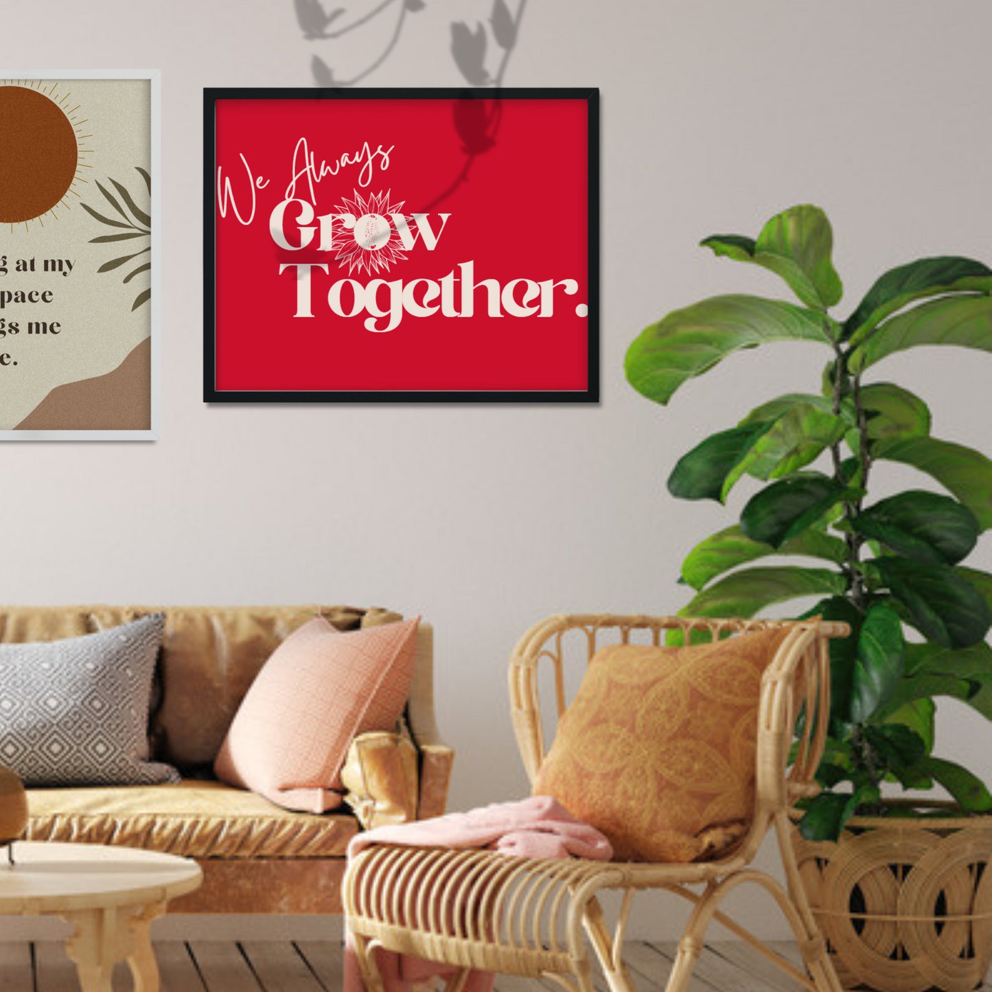 Picture of a workspace with black framed artwork on the wall. The red artwork has the words We Always Grow Together on it.