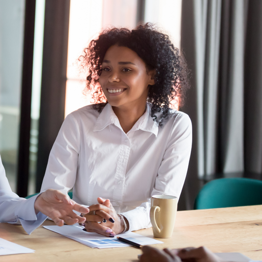 A happy woman at a conference table during a meeting at work. 
